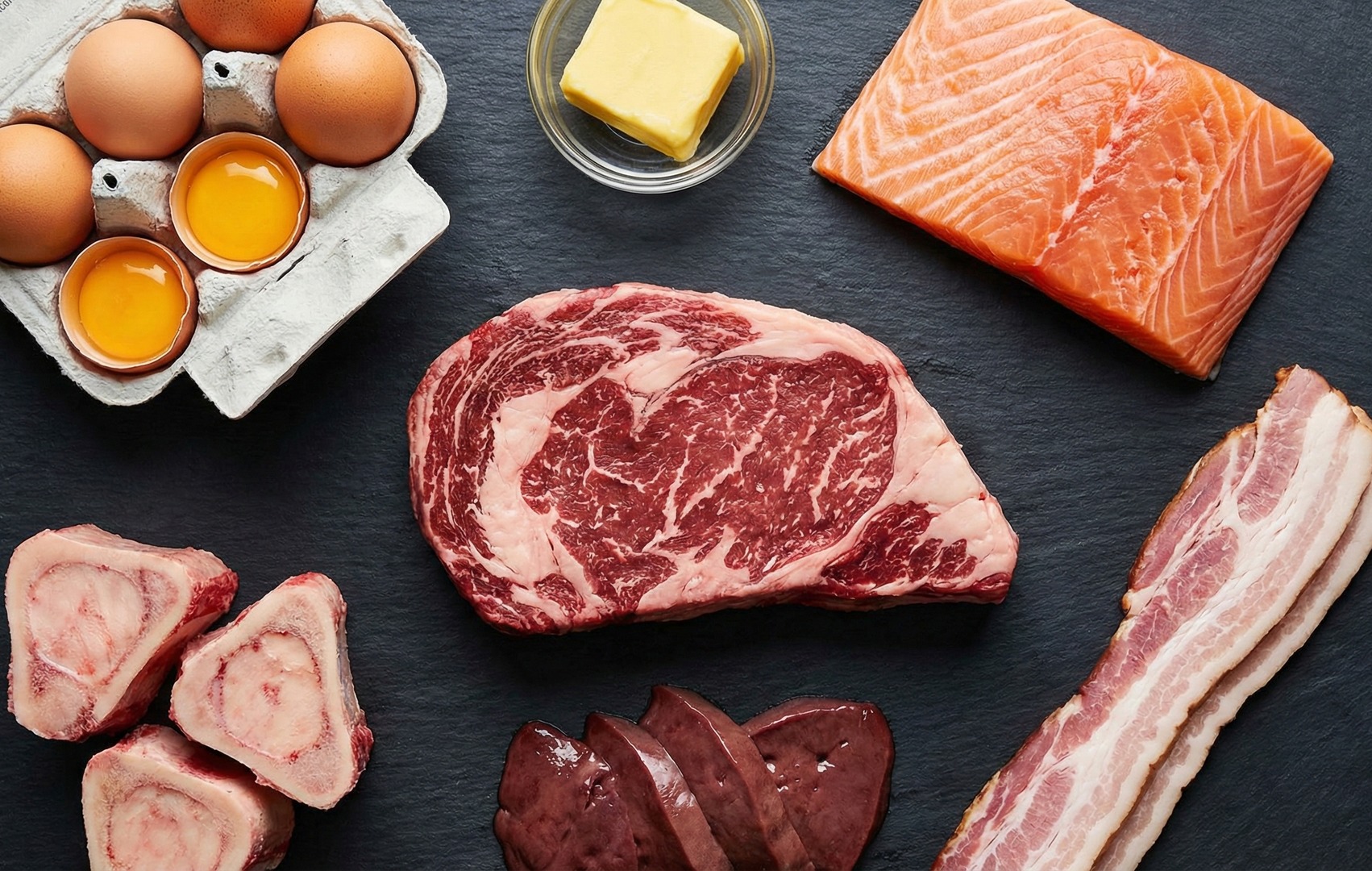 Alimente specifice dietei carnivore pe ardezie: ouă, unt, somon, antricot marmorat, os cu măduvă, ficat și bacon